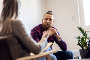 man in a flannel sits and talks to his therapist at his alcohol rehab in washington state